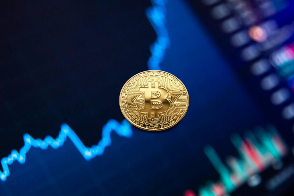 renda passiva A gold Bitcoin coin against a backdrop of a digital financial chart, symbolizing cryptocurrency trading.renda passiva