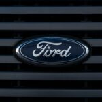 Detailed view of a Ford emblem mounted on a vehicle grille, showcasing modern design.