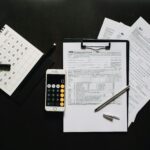 Flat lay of financial tools for tax preparation including forms, calculator, and calendar.