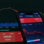 Mobile app showing stock market data with charts on screen.