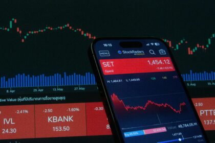 Mobile app showing stock market data with charts on screen.